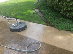 A concrete driveway that has been partly cleaned. There is a big difference between the cleaned section and the dirty section.