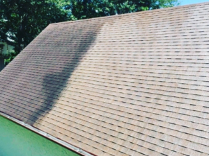 A roof that has been partly cleaned to show the before and after of using Eight Five O for roof cleaning